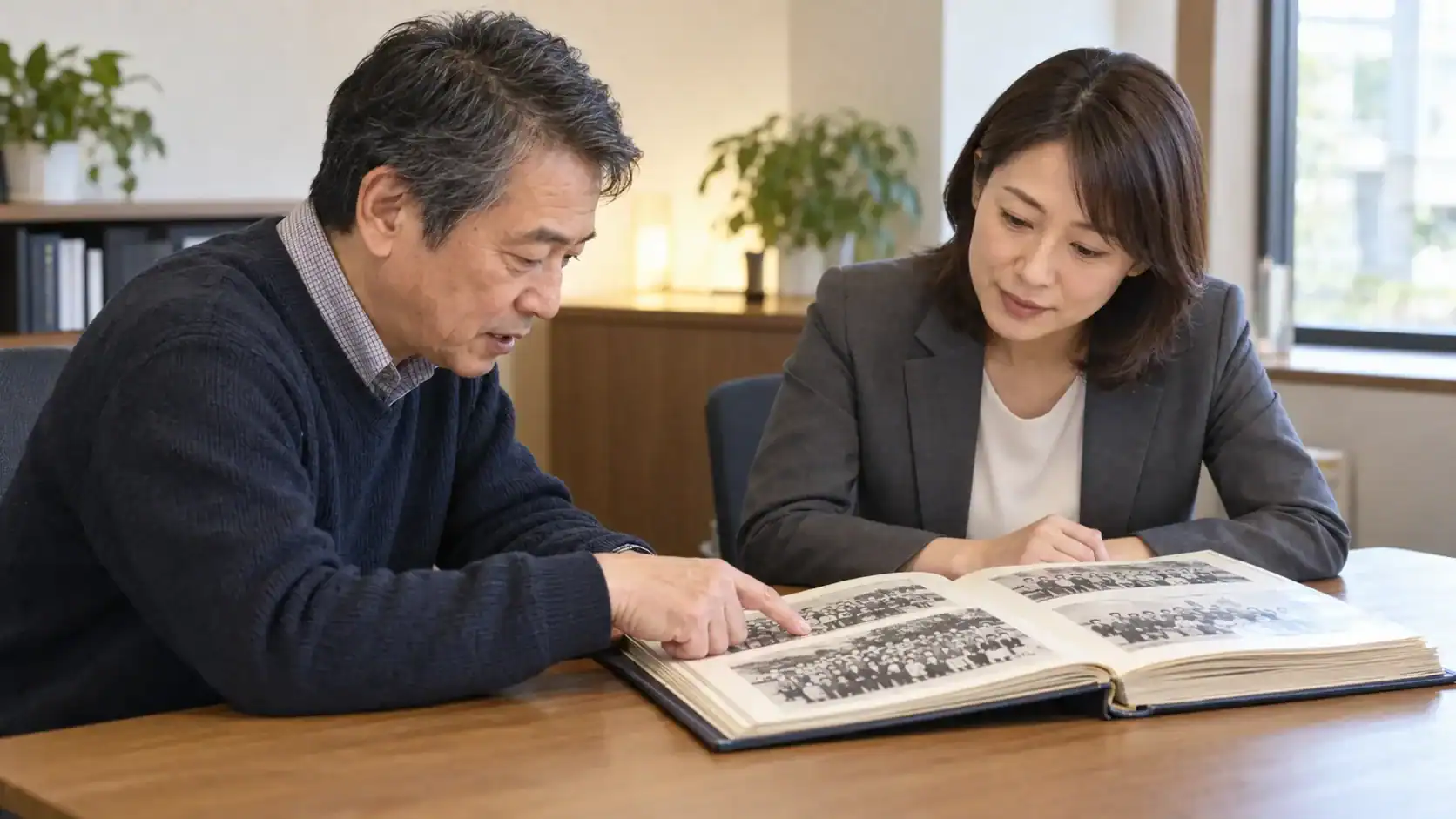 卒業アルバムを見ながら同級生の旧姓と在学時期を整理する依頼者と相談員